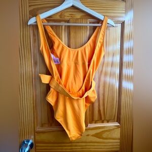 Tangerine colored bathing suit with belt accent.